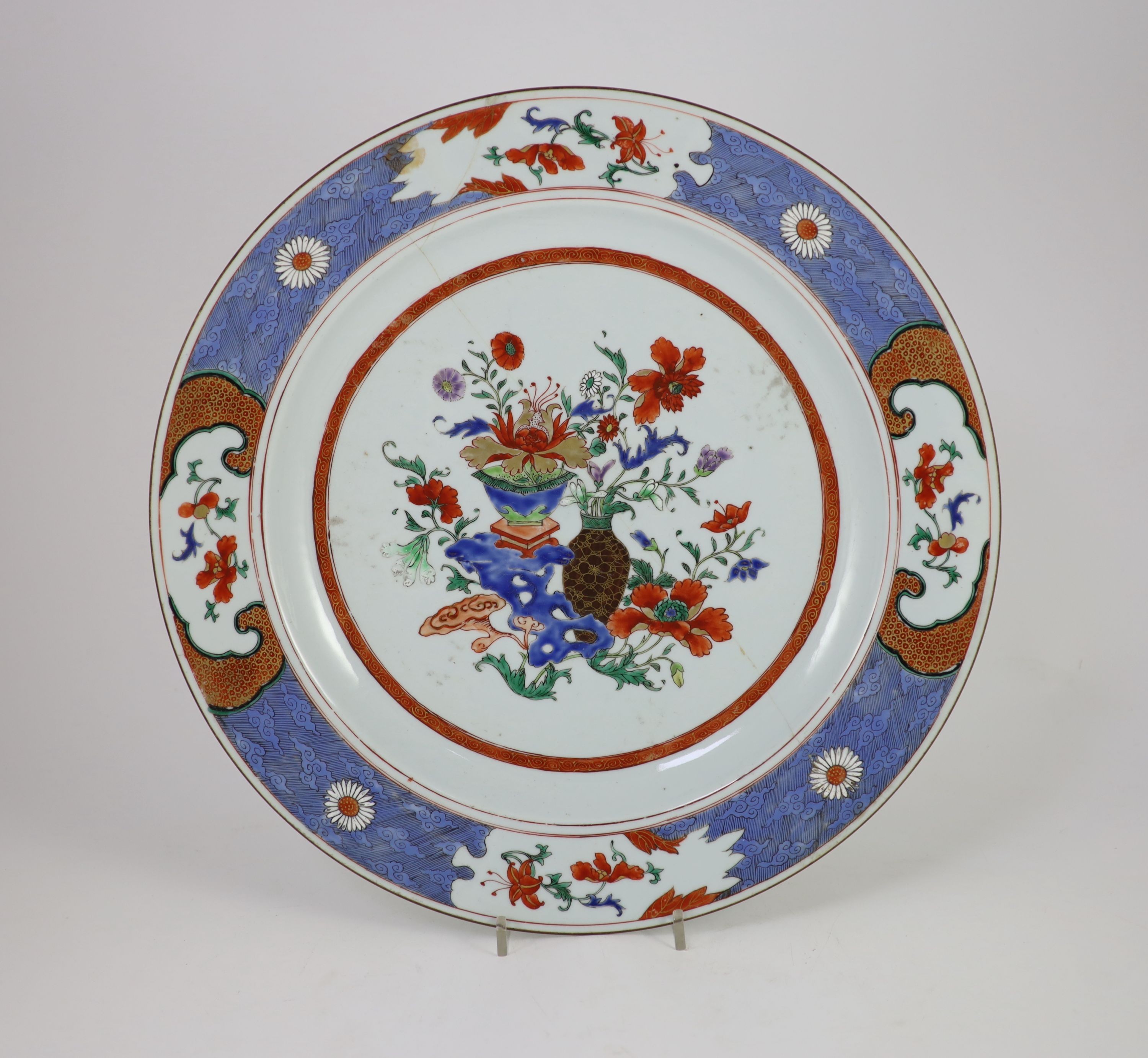 A pair of Chinese export famille rose dishes and a similar charger, early Qianlong period, diameter 35 cm and 42 cm, the charger broken and repaired